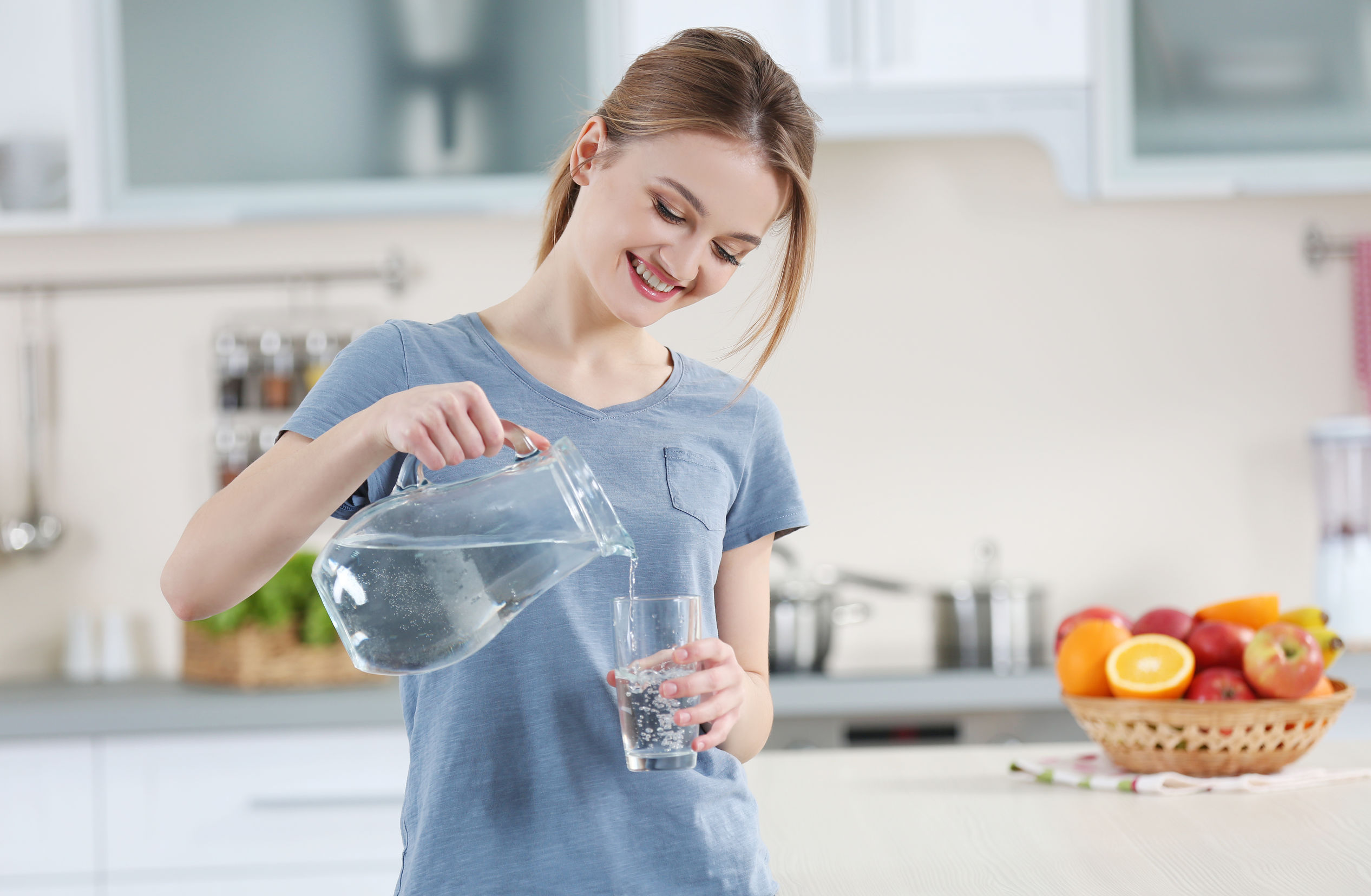 Набрать вес пить воду. Девушка наливает воду. Девушка пьет воду на кухне. Девушка со стаканом воды. Человек наливает воду.