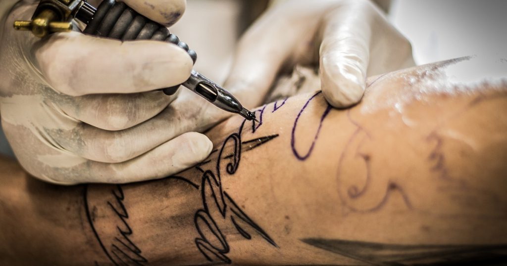 мужчина набивает татуировку