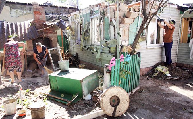На фото: жители Донецка на территории своего дома, который был разрушен в результате обстрела ВСУ
