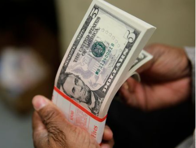 A packet of former U.S. President Abraham Lincoln five-dollar bill currency is inspected at the Bureau of Engraving and Printing in Washington March 26, 2015. REUTERS/Gary Cameron/Files