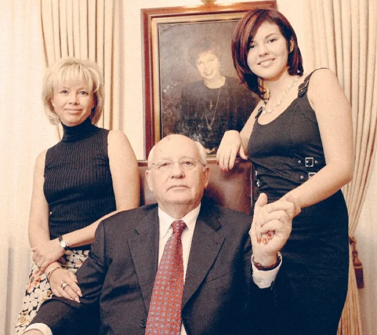 Ирина, Михаил Сергеевич и его внучка Анастасия на фоне портрета Раисы Горбачёвой 