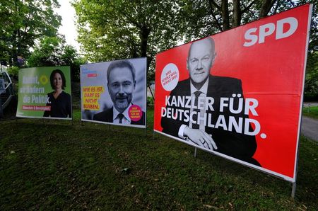 FILE PHOTO: Election posters of Social Democratic party (SPD) candidate for Chancellor Olaf Scholz, Christian Lindner of the liberal Free Democratic party FDP and the Greens party co-leader Annalena Baerbock are pictured in a park of Bad Honnef, south of Bonn, Germany, October 1, 2021. REUTERS/Wolfgang Rattay/File Photo 