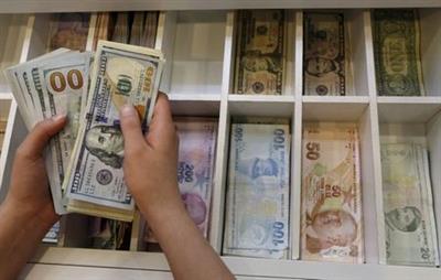 FILE PHOTO: A money changer counts U.S. dollar bills, with Turkish lira banknotes in the background, at an currency exchange office in central Istanbul, Turkey, August 21, 2015. REUTERS/Murad Sezer/File Photo