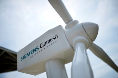FILE PHOTO: A model of a wind turbine with the Siemens Gamesa logo is displayed outside the annual general shareholders meeting in Zamudio, Spain, June 20, 2017. REUTERS/Vincent West/File Photo