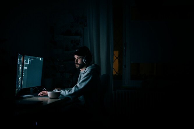 Мужчина работает за компьютером ночью