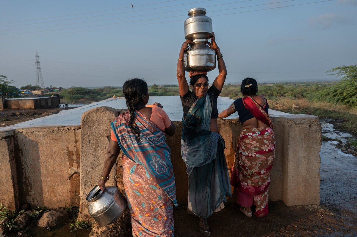 Женщины носят тяжёлые канистры с водой, чтобы приготовить пищу.