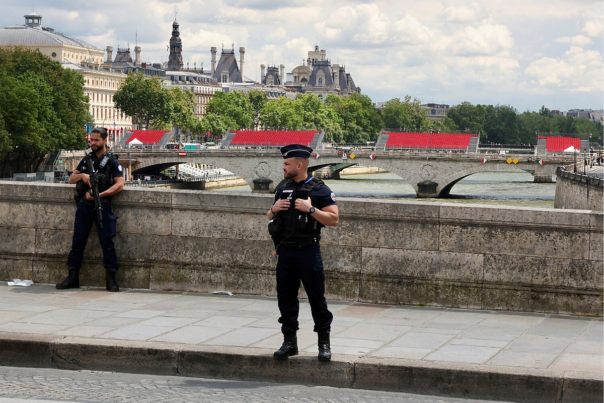 Полиция стоит поблизости от зрительских мест рядом с Нотр-Дамом в преддверии Олимпийских игр в Париже, июль 2024 года    ????