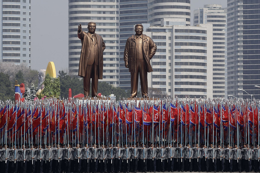 Студенты университета несут национальный флаг и две бронзовые статуи Ким Ир Сена и Ким Чен Ира во время военного парада в Пхеньяне, Северная Корея, 15.04.17 Вонг Майе-E, AP.png
