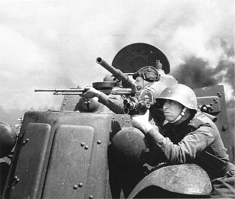 Советский кинооператор А. Эльберт ведет съемку у бронеавтомобиля БА-10. На заднем плане — один из членов экипажа бронеавтомобиля целится из пулемета ДТ. военная техника, вторая мировая война, история