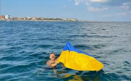 На фото: Феодосия, киевский блогер Антон Мурафа плывет с флагом Украины.