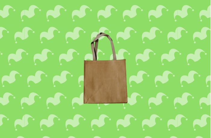 A brown reusable shopping bag against a green background