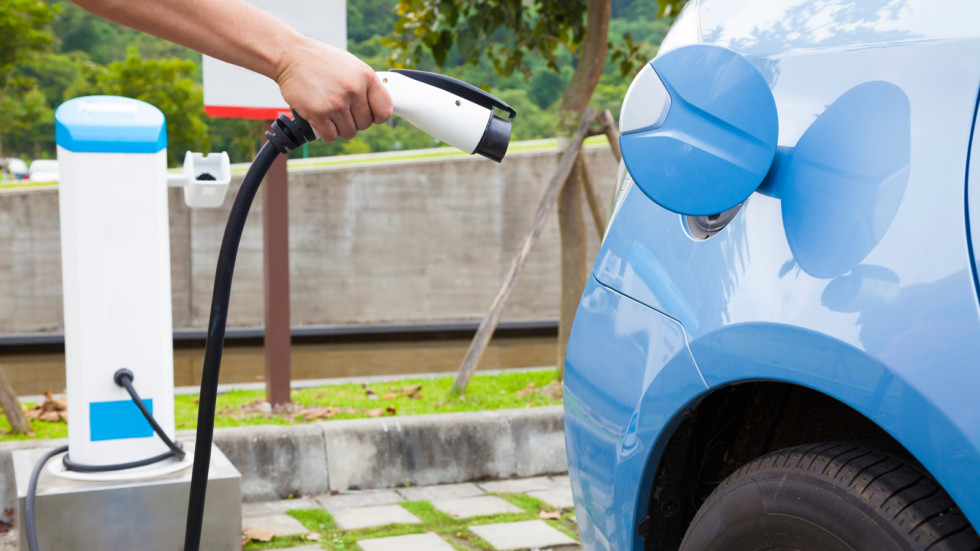 hand holding plug for Charging of an electric car in parking spa