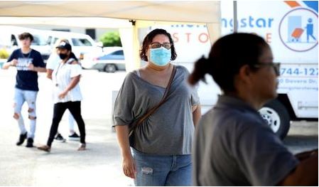 Lisandra Bonilla, who was furloughed from her job at an employment agency due to the coronavirus disease (COVID-19) pandemic, helps set up the 'It Takes a Village' clothing and provisions outreach event, part of the extensive volunteer work she does, in Kissimmee, Florida, U.S., October 24, 2020. Picture taken October 24, 2020. REUTERS/Gregg Newton