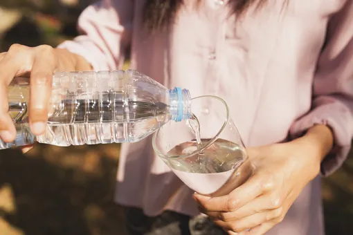Девушка наливает воду в стакан