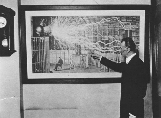  Тесла демонстрирует фотографию своей лаборатории с проходящим по ней разрядом электричества 1916 год