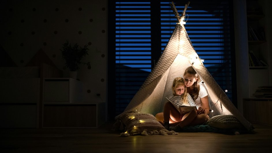 Мать читает ребенку книжку перед сном