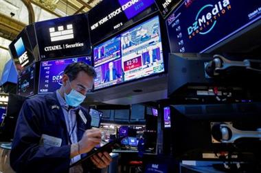 A trader works, as Federal Reserve Chair Jerome Powell is seen delivering remarks on screens, on the floor of the New York Stock Exchange (NYSE) in New York City, U.S., January 26, 2022. REUTERS/Brendan McDermid