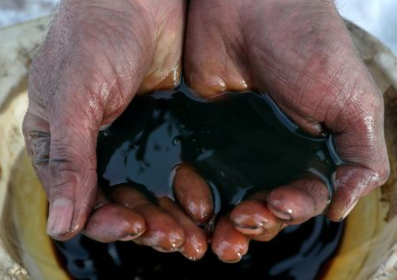 FILE PHOTO: An employee holds a sample of crude oil at the Yarakta oilfield, owned by Irkutsk Oil Co, in the Irkutsk region, Russia on March 11, 2019. REUTERS/Vasily Fedosenko//File Photo