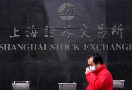 FILE PHOTO: A men wearing a mask walk at the Shanghai Stock Exchange building at the Pudong financial district in Shanghai, China, as the country is hit by an outbreak of a new coronavirus, February 3, 2020. REUTERS/Aly Song/File Photo