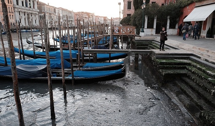В Венеции гондолы стоят в грязи.
