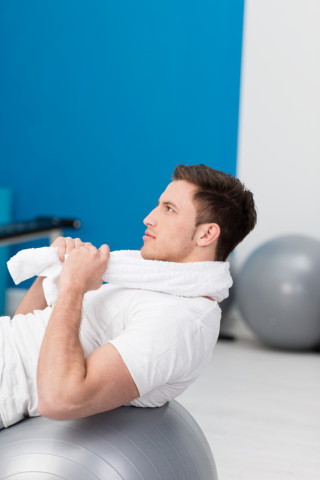 Young man working out using a gym ball