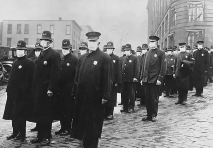 Полицейские стоят на улице в Сиэтле, Вашингтон, в защитных масках, изготовленных сиэтлийским отделением Красного Креста, во время эпидемии гриппа в 1918 году