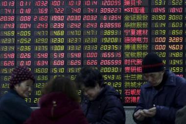 FILE PHOTO: Investors stand in front of an electronic board showing stock information on the first trading day after the week-long Lunar New Year holiday at a brokerage house in Shanghai, China, February 15, 2016. China stocks opened more than 2 percent lower on Monday, as they played catch-up with bearish global markets after the week-long Lunar New Year holiday. REUTERS/Aly Song/File Photo 