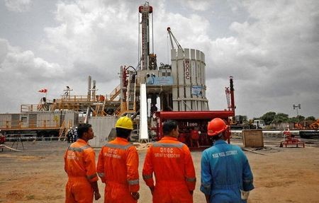 Technicians stand next to an oil rig which is manufactured by Megha Engineering and Infrastructures Limited (MEIL) at an Oil and Natural Gas Corp (ONGC) plant, during a media tour of the plant in Dhamasna village in the western state of Gujarat, India, August 26, 2021. REUTERS/Amit Dave