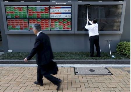 A man (R) cleans electronic boards showing Japan's Nikkei average, the exchange rate between the Japanese yen against the U.S. dollar and stock quotation outside a brokerage in Tokyo, Japan, in this April 6, 2016 file photo. REUTERS/Issei Kato/Files