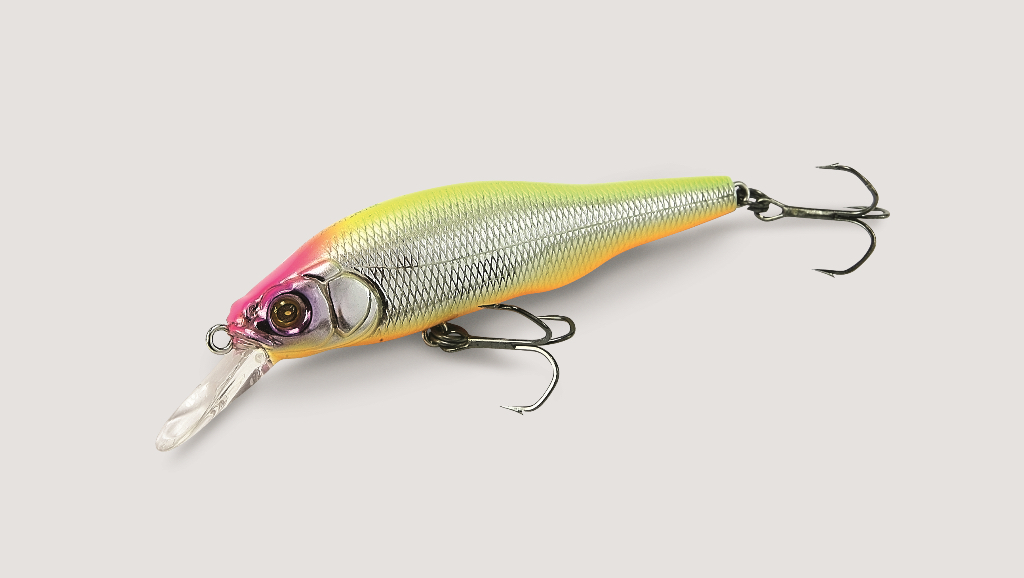 Megabass X-80 Rocket Darter (10,9 г — 80 мм). Этот воблер существует не первый год, но до недавнего времени я не уделял ему должного внимания. Поездка на мои любимые речки в Нижегородской области предполагала ловлю на глубине около 1,5–2 м. Собственно, для этого он и был приобретён. Лучшая проводка — в виде резких двойных рывков, аналогичных по ритму стуку колесной пары поезда. Сравнение необычное, но оно характеризует самую подходящую проводку. Темп рывков может быть различным: от быстрого, когда за секунду следует успевать сделать два рывка и такую же по продолжительности паузу, до медленного — чуть более секунды на пару рывков и 2-3-секундная пауза. На водоёмах со спокойной водой X-80 актуален для ловли капризной щуки на глубинах 1,5–2 м. Особенно хороши для облова этим воблером бровки с глубиной 1,5–2 м. Для небольшой реки с течением данная модель тоже окажется вполне актуальной. Возможна проводка в постоянном темпе, но лишь в случае высокой активности щуки. Воблер тонущий, поэтому после второго рывка не следует давать слабину, чтобы приманка оставалась и погружалась в горизонтальном положении, а не «солдатиком».