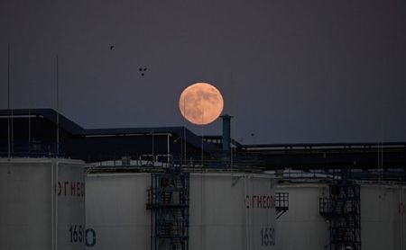 FILE PHOTO: The moon rises behind the storage tanks of a local oil refinery in Omsk, Russia June 5, 2020. REUTERS/Alexey Malgavko