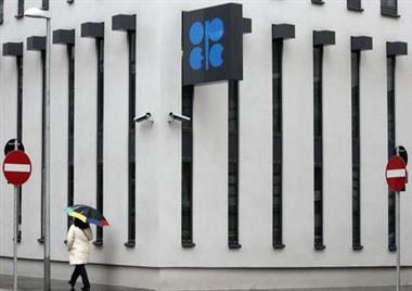 A woman with an umbrella walks past the logo of the Organization of the Petroleum Exporting Countries (OPEC) at the new OPEC headquarters during rainfall in Vienna March 16, 2010. OPEC oil ministers gather for the 156th OPEC meeting in Vienna on Wednesday. REUTERS/Heinz-Peter Bader (AUSTRIA - Tags: POLITICS ENERGY IMAGES OF THE DAY)