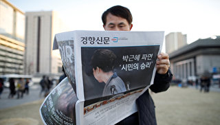 Мужчина читает газету с новостью об импичменте Пак Кын Хе, Сеул. 10 марта 2017 год