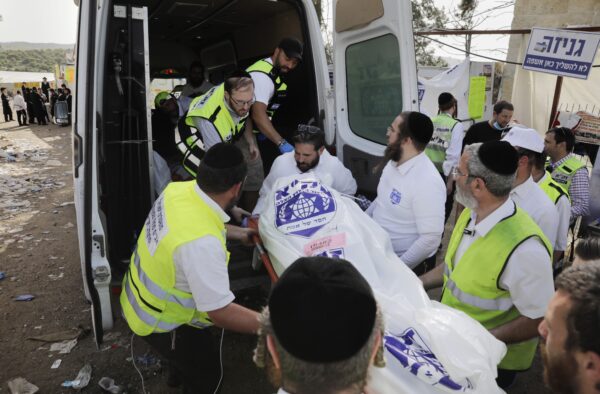 Сотрудники службы безопасности и спасатели Израиля несут тело жертвы, погибшей во время празднования Лаг-Баомер на горе Мерон на севере Израиля 30 апреля 2021 г.