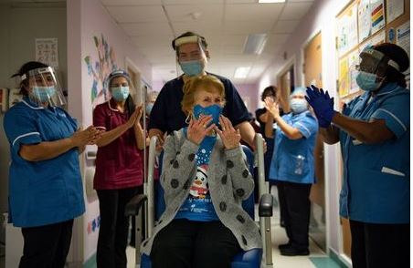 Margaret Keenan, 90, is applauded by staff as she returns to her ward after becoming the first person in Britain to receive the Pfizer/BioNTech COVID-19 vaccine at University Hospital, at the start of the largest ever immunisation programme in the British history, in Coventry, Britain December 8, 2020. Britain is the first country in the world to start vaccinating people with the Pfizer/BioNTech jab. Jacob King/Pool via REUTERS
