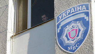 Милиционер смотрит из окна здания областного управления МВД Украины