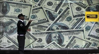 FILE PHOTO: A security guard walks past a montage of old U.S. dollar bills outside a currency exchange in Kenya's capital Nairobi July 23, 2015. REUTERS/Thomas Mukoya/File Photo