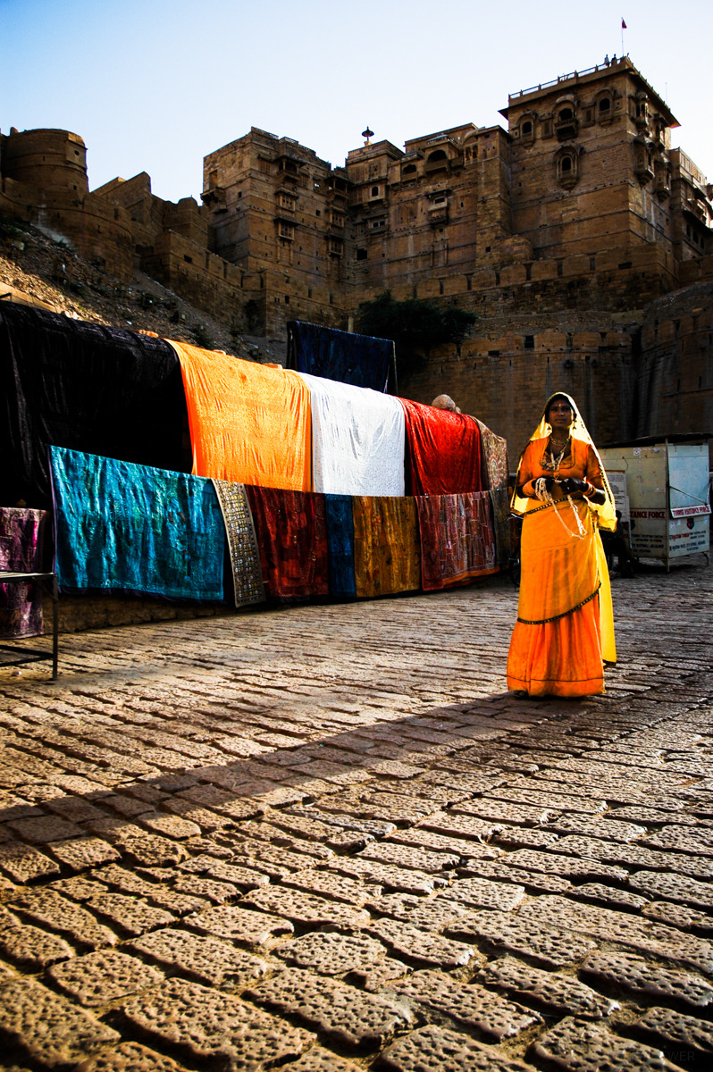 Woman Selling birghtly colored carpets outside the the Jaisalmer fort in Rjastan, India