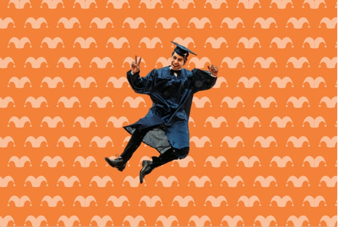 A man dressed in a cap and gown is jumping against an orange background.