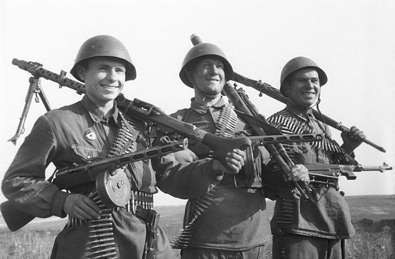 Солдаты-гвардейцы с захваченным немецким стрелковым оружием. У бойца слева на плече немецкий пулемет MG-34, в качестве личного оружия двое вооружены пистолетами-пулеметами системы Шпагина (ППШ). У солдата в центре карабины «Маузер», у бойца справа на Великая Отечественная война, СССР, Солдаты моей страны