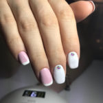 Бело розовый френч с белыми безымянным и средним пальцами, на которых аккуратно вписались стразы