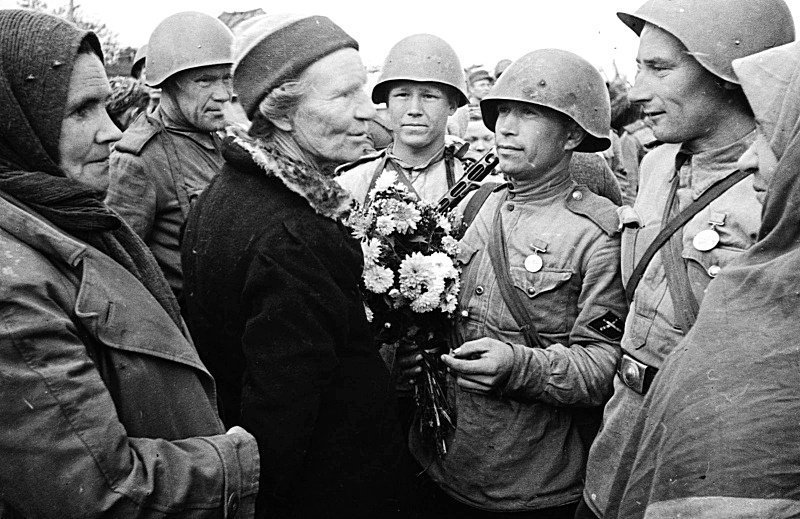 Мирные жители приветствуют советских солдат-артиллеристов истребительного противотанкового подразделения. Великая Отечественная война, СССР, Солдаты моей страны
