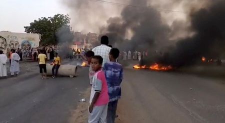 Alcune persone si affollano nelle strade di Kartoum, dove imperversano fiamme e fumo, mentre vengono riportate notizie di un possibile colpo di Stato. Sudan, 25 ottobre 2021. Fotogramma da video diffuso sui social RASD SUDAN NETWORK via REUTERS 