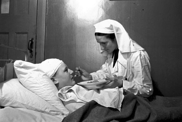 Медсестра Козлова А. кормит раненого майора Ногина В. в госпитале № 2-386.