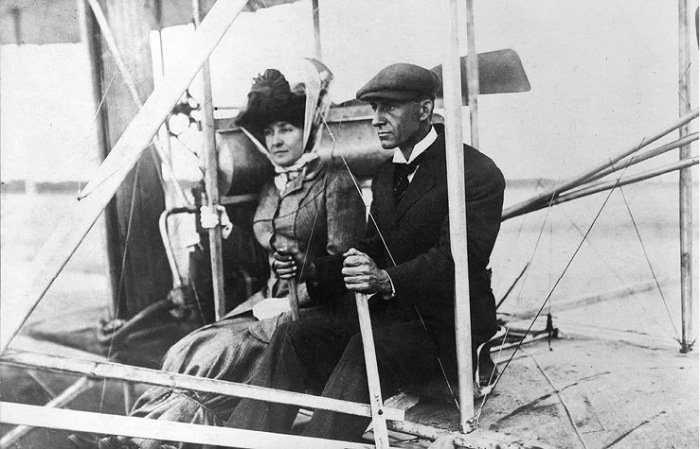 Эдит Берг в юбке, перевязанной веревкой, с Уилбором Райтом на аэроплане. Сентябрь 1908 года