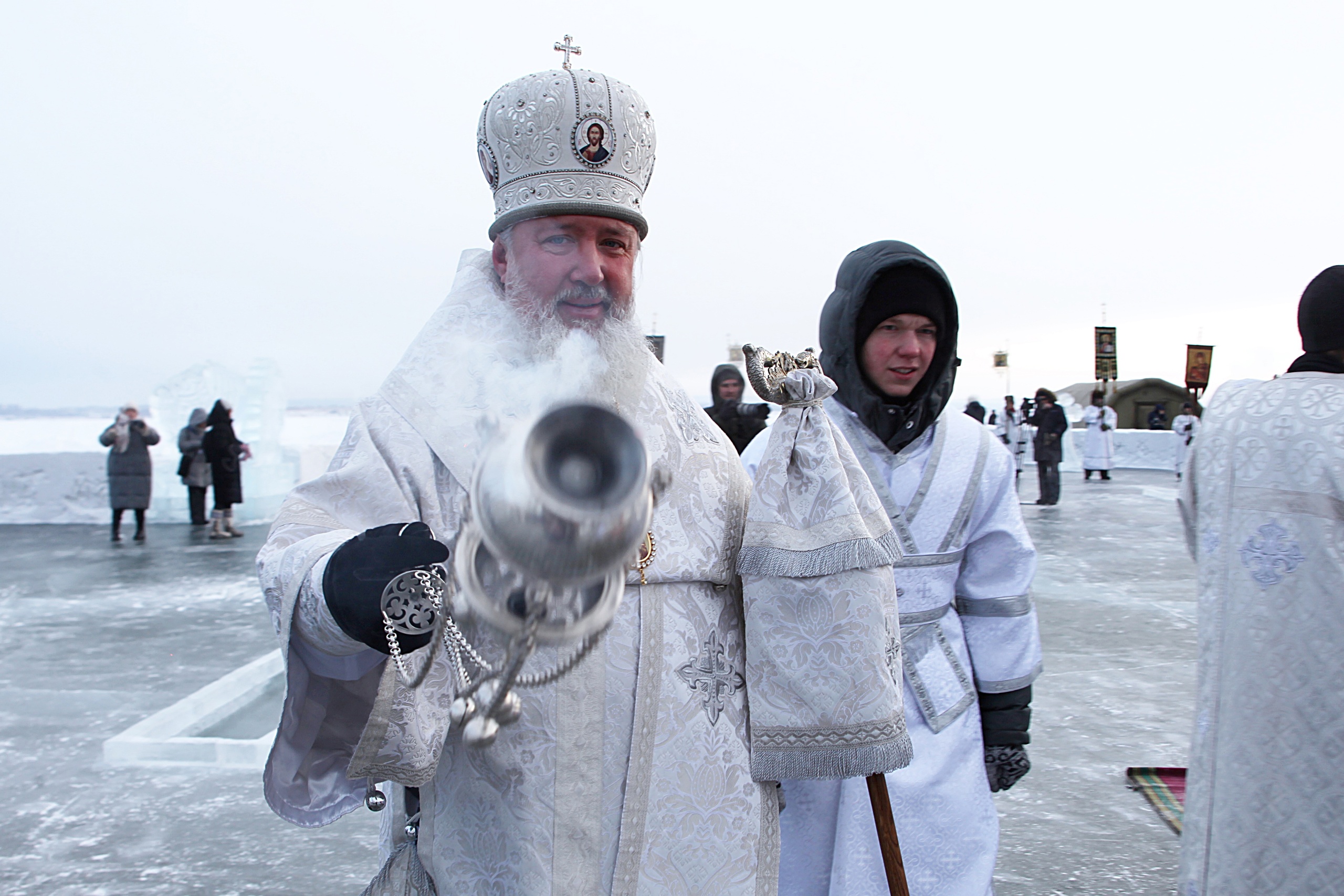 Священник освящает