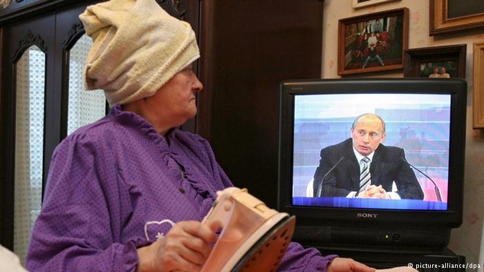 злорадно ухмыляющийся Путин в телевизоре