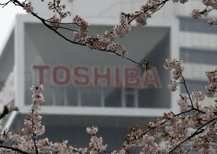 The logo of Toshiba Corp is seen behind cherry blossoms at the company's headquarters in Tokyo, Japan April 11, 2017. REUTERS/Toru Hanai