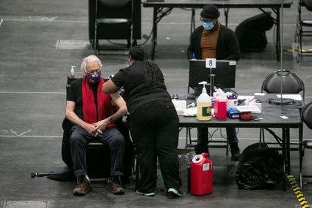 A man receives a dose of the coronavirus disease (COVID-19) vaccine at the New York State COVID-19 vaccination site at the Jacob K. Javits Convention Center, in New York City, U.S., January 13, 2021. REUTERS/Brendan McDermid