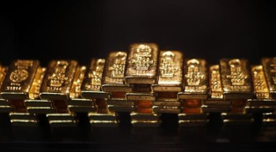 Gold bars are stacked at a safe deposit room of the ProAurum gold house in Munich March 6, 2014. Gold was flat on Thursday as diplomatic efforts to cool the Ukraine crisis depressed demand for assets seen as safe, but the metal found support above $1,330 an ounce from weak U.S. economic data and ahead of a key employment report. REUTERS/Michael Dalder(GERMANY - Tags: BUSINESS COMMODITIES SOCIETY)